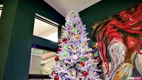 Festive purple Xmas tree glowing in modern green room with abstract red art