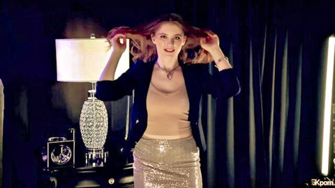 Seductive redhead babe in blazer and sparkly skirt tossing long hair teasingly