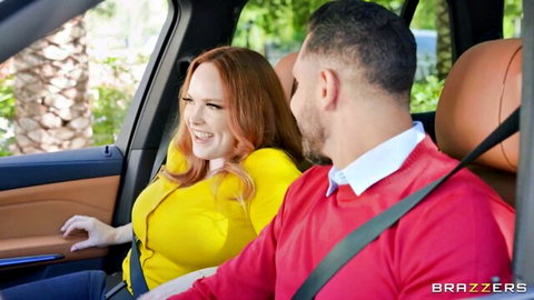 Busty redhead with glasses in tight yellow top smiles flirtatiously at man in luxury car