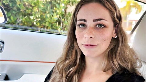 Renee Rose blonde freckled beauty smiling in car, teasing threesome vibe