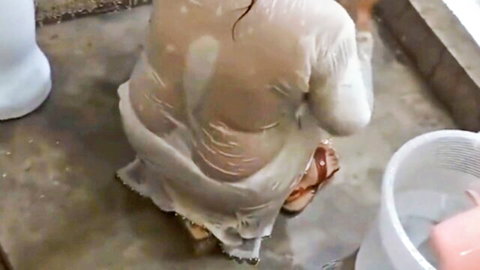 Big-booty Pakistani MILF in wet see-through white dress, squatting in bathroom