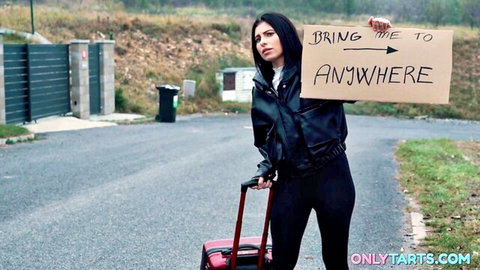 Lilly Bella hitchhiking in leather jacket on road adventure