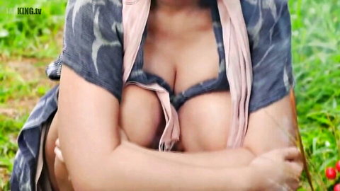 Busty Indian woman teasing cleavage in open blouse outdoors