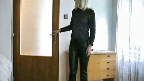 Blonde MILF in sequined top and leather pants posing by door