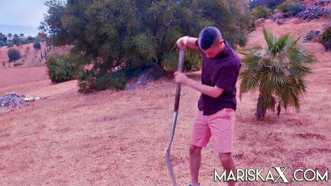 Sam frolics outdoors in nature with Lyne, holding a long pole in sunny hills