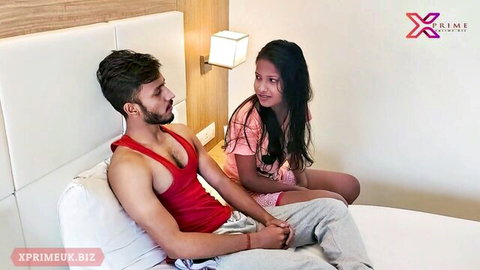 Indian couple cuddling on bed, young man and woman in casual wear