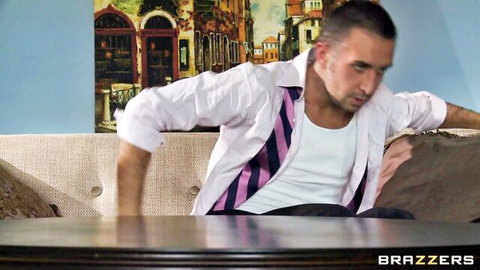 Muscular man in white shirt and striped tie exposes huge erect cock from open pants on couch