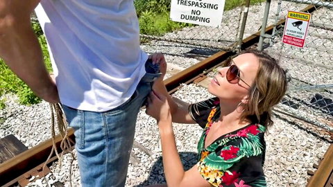 Slim beautiful MILF kneels for risky outdoor handjob near train tracks
