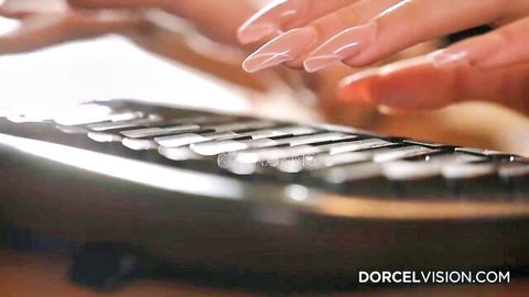 Sexy long-nailed hands typing on black office keyboard closeup