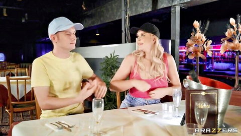 Blonde babe in pink tank top and shorts flirts with handsome guy at champagne dinner table