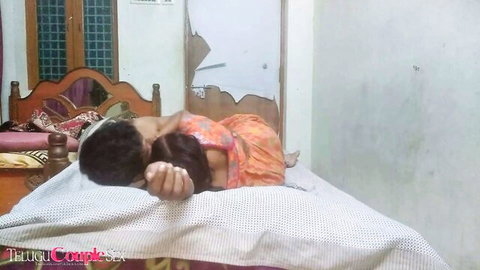 Desi Indian couple embracing intimately on bed in saree