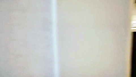 Empty white room interior with plain walls and no visible action or nudity