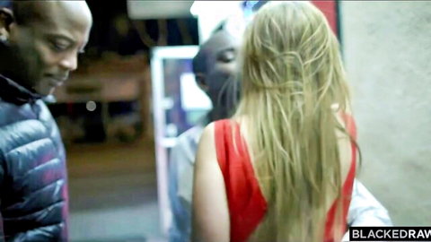 Blonde babe in tight red dress flanked by two black BBC studs on dark urban street teasing interracial threesome