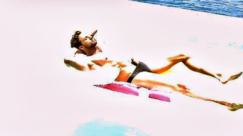 Muscular blond man lounging on pool float in black trunks, hot threesome tease