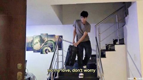 Young handsome guy in gray tee and jeans carries black suitcase down modern stairs