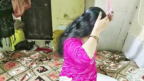 Sexy Indian housewife in pink saree lifting long black hair from behind in bedroom