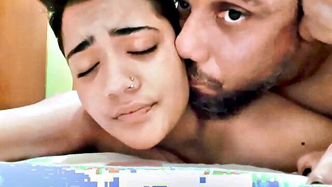 Bearded man kissing topless woman's neck as her perky tits spill out in amateur bedroom passion