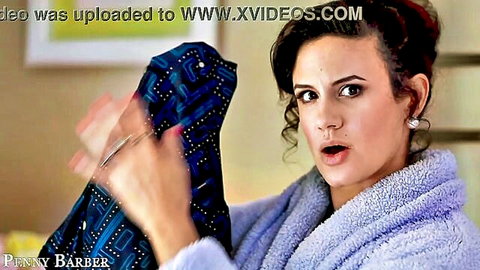Penny Barber in fluffy robe holding blue diaper with scissors, surprised diaper fetish tease