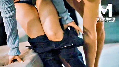 Asian woman in gray sleeves pulling down black pants, exposing thighs in JAV erotic scene