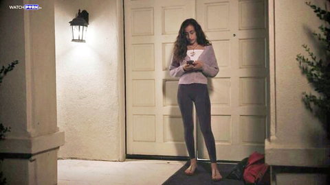 Scarlett Page in pink sweater and gray leggings, teasing outside at night
