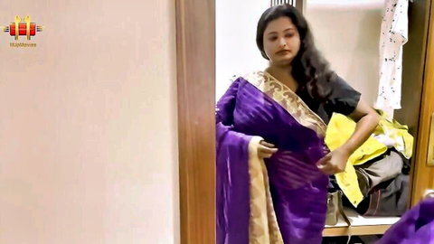 Curvy Indian woman in purple sari adjusting dress in teasing pose