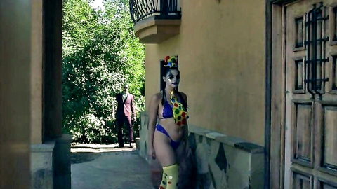 Violet Starr in colorful bikini and stockings poses with man outdoors