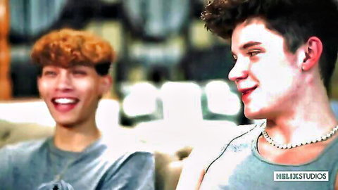 Two young smiling studs with curly hair in casual gray tops, intimate pose