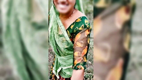 Smiling Indian Bhabhi in green saree outdoors, teasing vibe