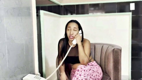 Seductive mixed-race woman in tube top and pants on steamy phone call