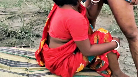Desi boudi in red saree sits outdoors as man touches her intimately