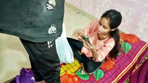 Indian desi aunty in pink top sits on bed with young man, teasing home romp