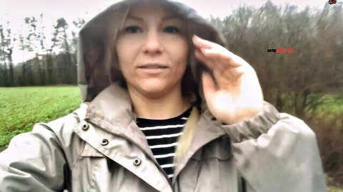 Blonde Bibixxx in rain jacket outdoors, teasing for public BJ adventure