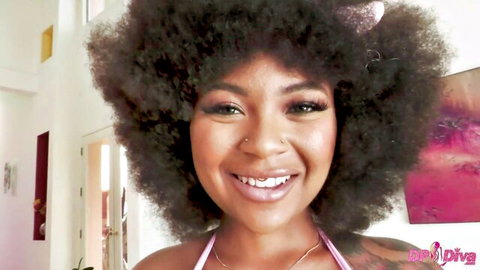Smiling ebony babe with massive curly afro and glossy lips in pink top