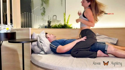 Blonde babe in gray sports bra and sweats teases relaxed guy lying on round bed