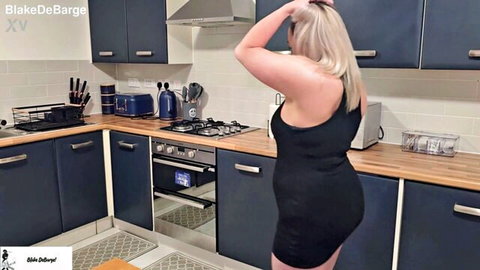 Blonde Blake DeBarge in tight black dress, teasing in kitchen