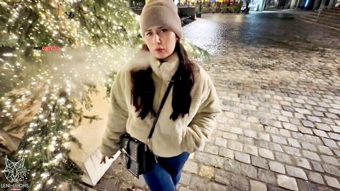 Leni-Luchs in cozy beanie and puffer jacket, teasing outdoors under Christmas lights