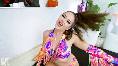 Young skinny brunette with small tits in psychedelic fringe bikini teases wildly with flying ponytail and open mouth