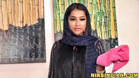 Yasmina Khan in hijab and sparkly outfit, teasing with pink glove