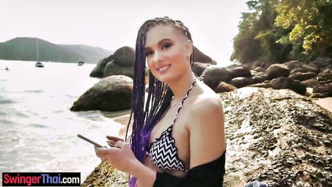 KissCat in zigzag bikini on Brazilian beach, purple braids, smiling with phone