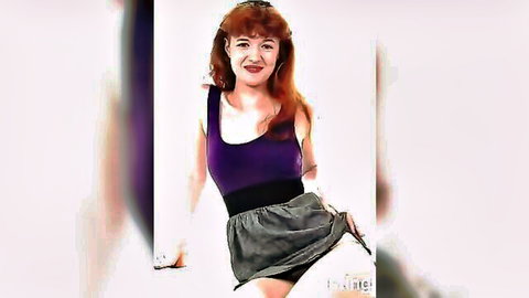 Busty redhead babe in purple tank top and gray skirt posing seductively