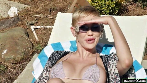 Blonde tgirl with big tits in sparkly bikini top shades eyes outdoors