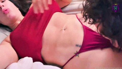 Brunette bombshell in red thong and top sprawls on bed flashing toned abs navel piercing and hip tattoo
