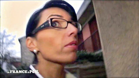 Seductive brunette MILF in glasses smirks passionately outdoors