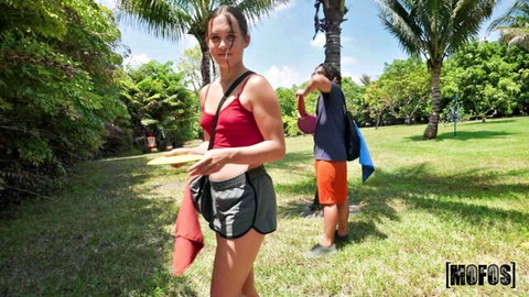 Daisy Pheonix in red tank top and gray shorts, frisky at outdoor park