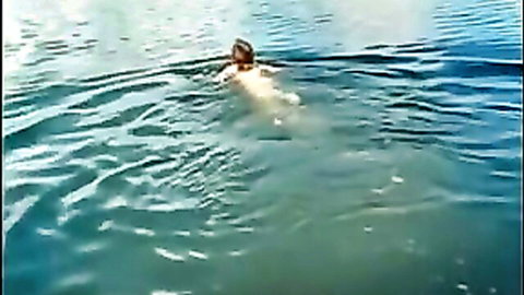 Nude brunette babe swims underwater in outdoor pool exposing bare ass and body