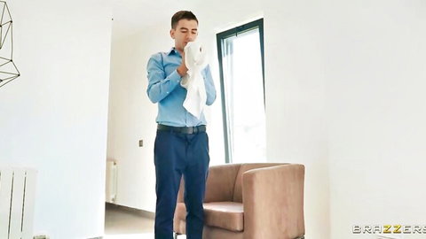 Handsome man in blue shirt wiping face with white towel in modern room