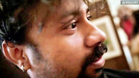 Close-up of intense Indian man with mustache and earring staring passionately