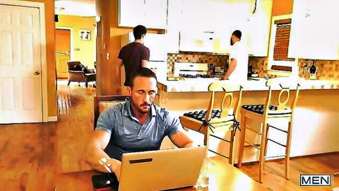 Mustached athletic guy on laptop while two hot shirtless hunks stand in kitchen teasing gay action