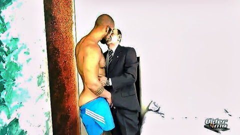 Muscular young man passionately kisses older suited man in intimate embrace