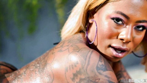 Gogo Fukme poses seductively from behind with tattoos and blonde hair